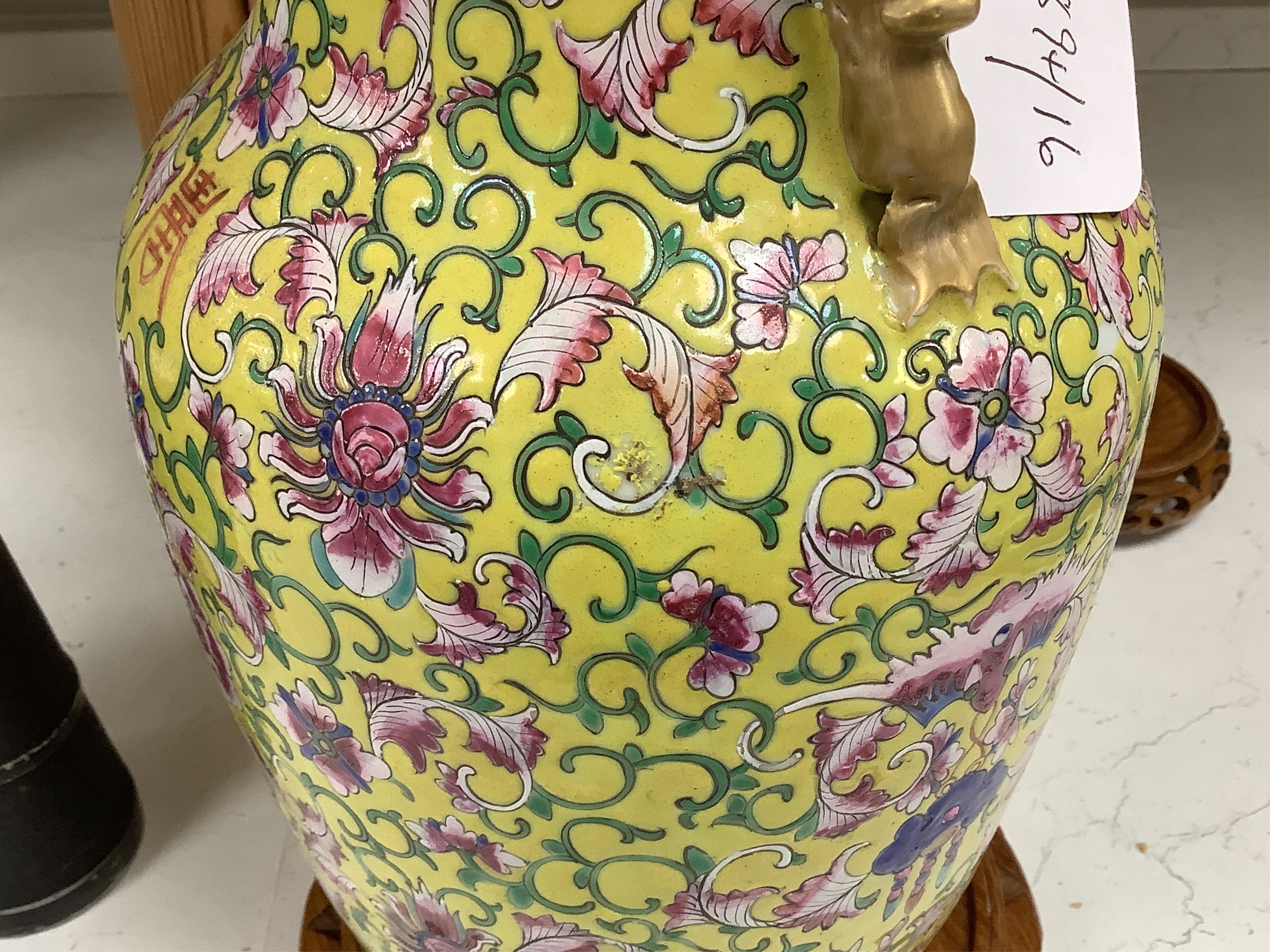 A late 19th century Chinese yellow ground porcelain vase, with gilt chilong handle, decorated with flowers and tendrils, iron red bands to the scalloped neck (including two stands), 35cm high. Condition - chip to top edg